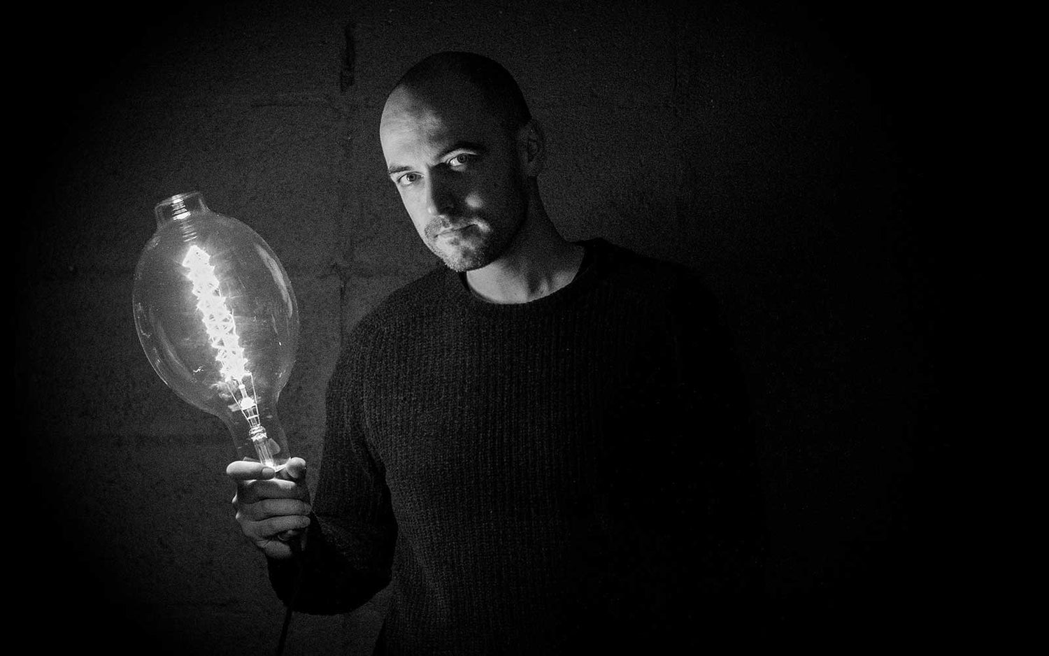 Emmet-Bosonnet-of-kopper-kreation-holding-an-oversized-vintage-edison-filament-incandescent-bulbs-in-Dublin-Ireland